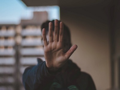 Image of person holding up their hand to the camera